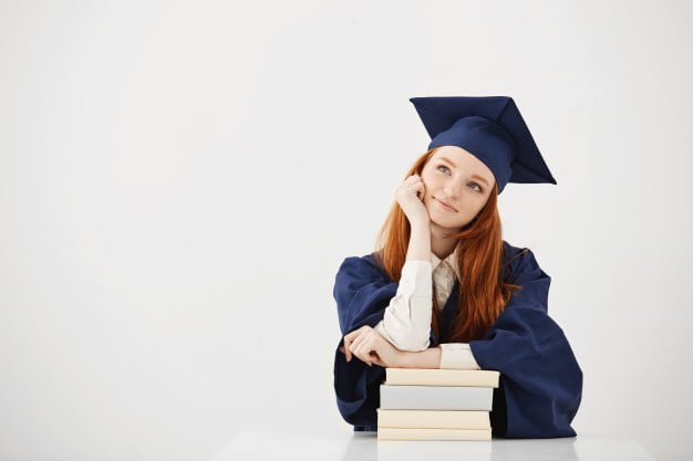 dreamy graduate woman smiling thinking sitting with books 176420 14255