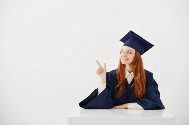 young female university graduate academic cap sitting table smiling pointing left future lawyer engineer showing idea 176420 14245